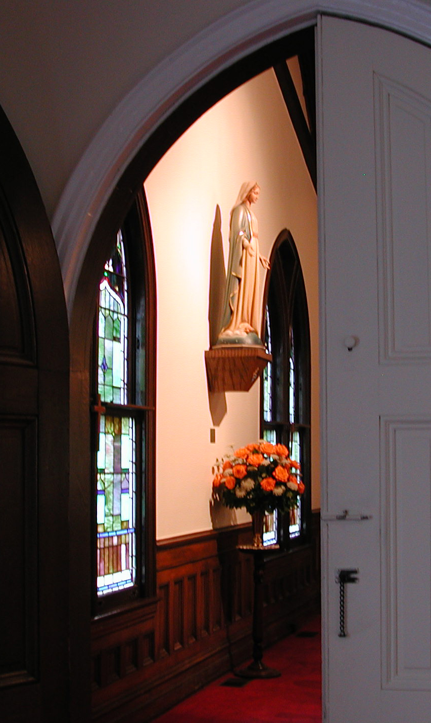 Flowers under statue of Mary